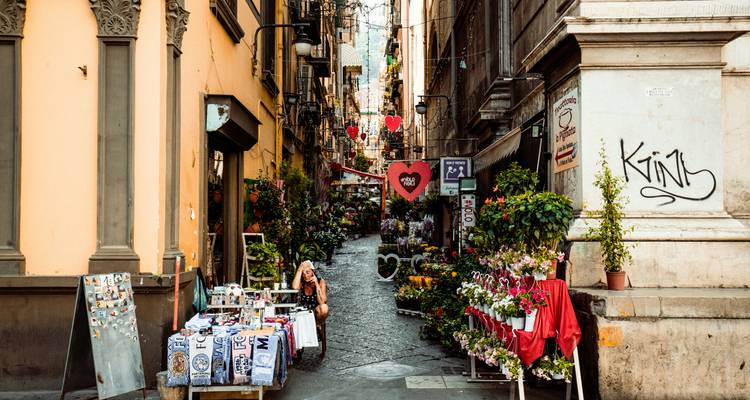 Street in Naples with market stalls and vibrant colors.