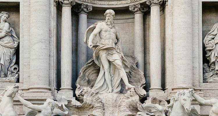 Baroque fountain with sculptures in dynamic poses under sunlight.