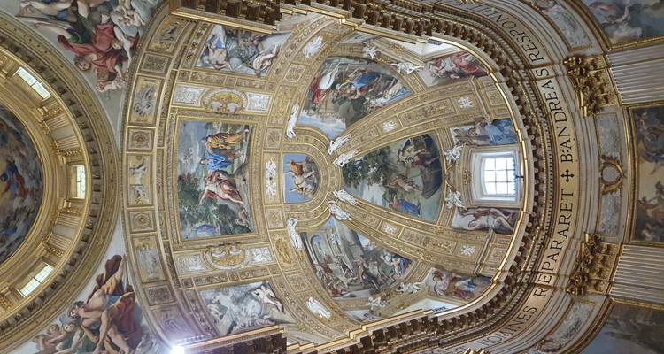Richly decorated dome interior with colorful frescoes and gold accents.