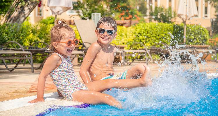Deux enfants jouant joyeusement près d'une piscine.