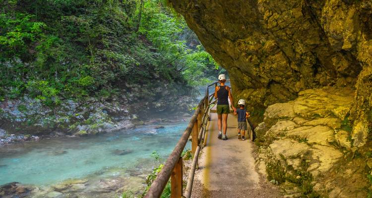 Parent et enfant faisant de la randonnée le long d'un sentier au bord d'une rivière.