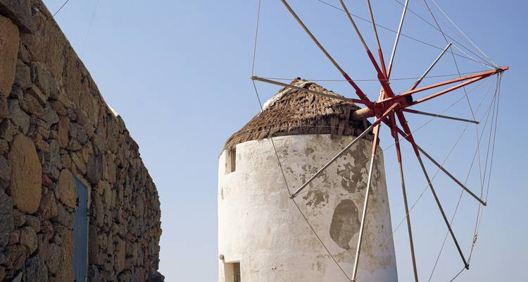 Traditionelle Windmühle vor blauem Himmel.