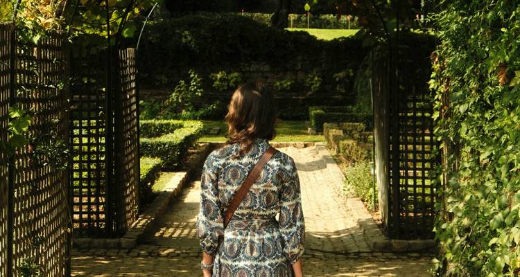 Persoon die door een aangelegde tuin loopt.