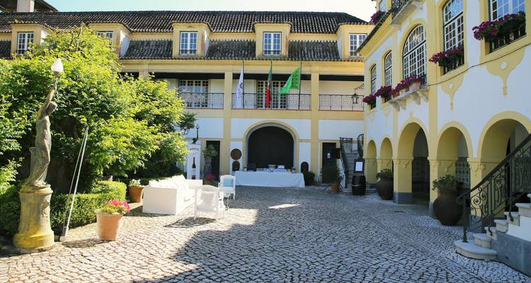 Historic courtyard with flags and flowers in a traditional setting.