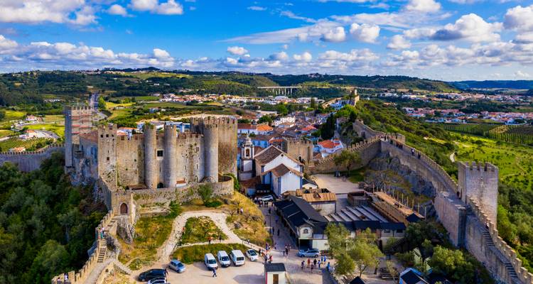 Vue aérienne d'une forteresse médiévale avec la ville environnante.