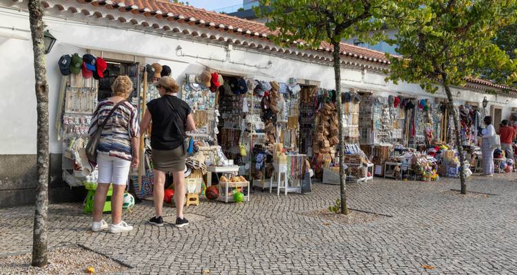 Un marché avec des gens qui parcourent les marchandises le long d'une rangée de boutiques.