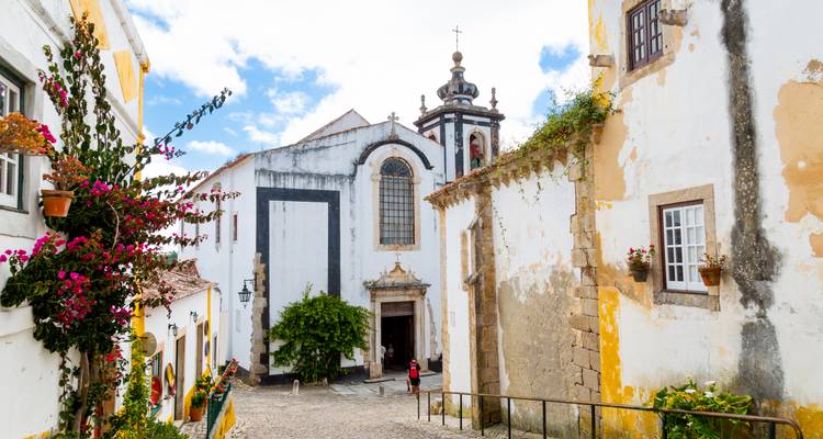 Une rue pittoresque avec une église historique et des bâtiments colorés.