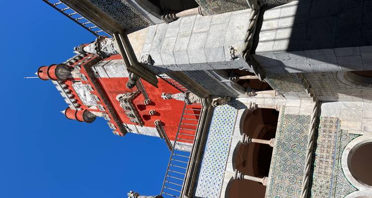Ornate palace tower with intricate details under a blue sky.