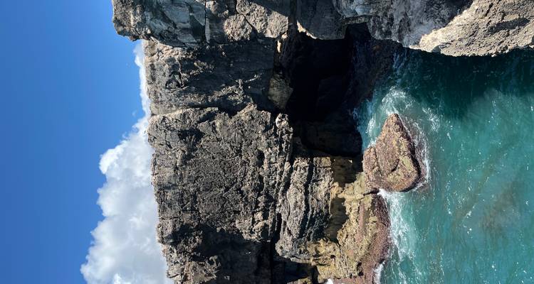 Rocky cliffs with turquoise water below.