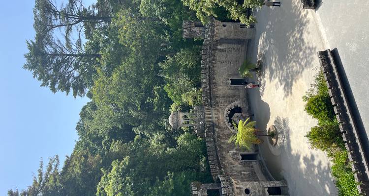 Circular courtyard surrounded by trees and walls with visitors.