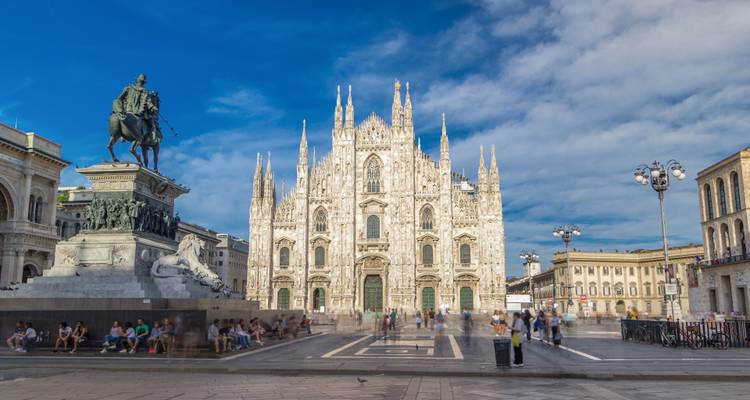 Piazza del Duomo met de Kathedraal van Milaan en ruiterstandbeeld, vol met mensen.