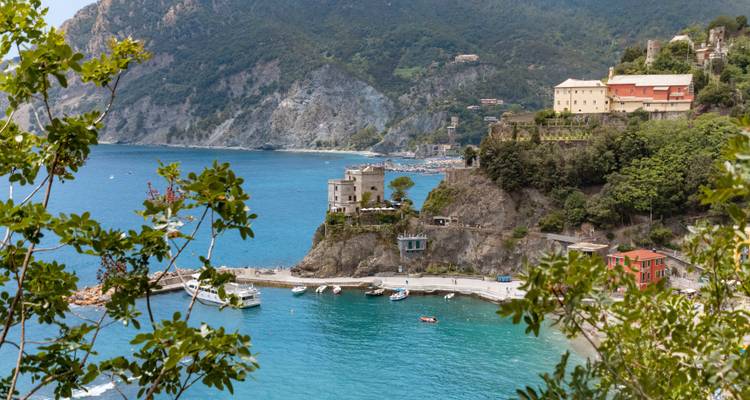 Schilderachtig uitzicht op een kustlijn met kliffen en gebouwen die boven kristalhelder water uitsteken.