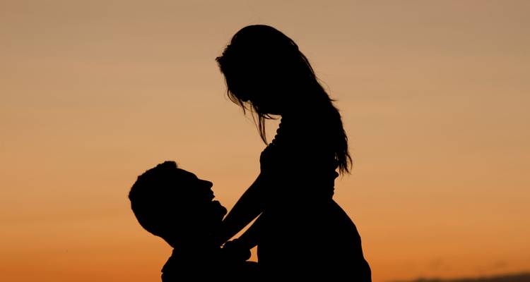 Silueta de una pareja contra un cielo al atardecer.
