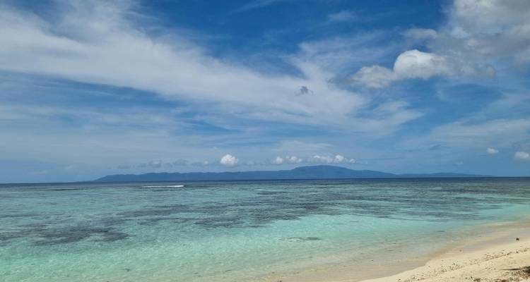 Vista de un mar tranquilo con montañas distantes.