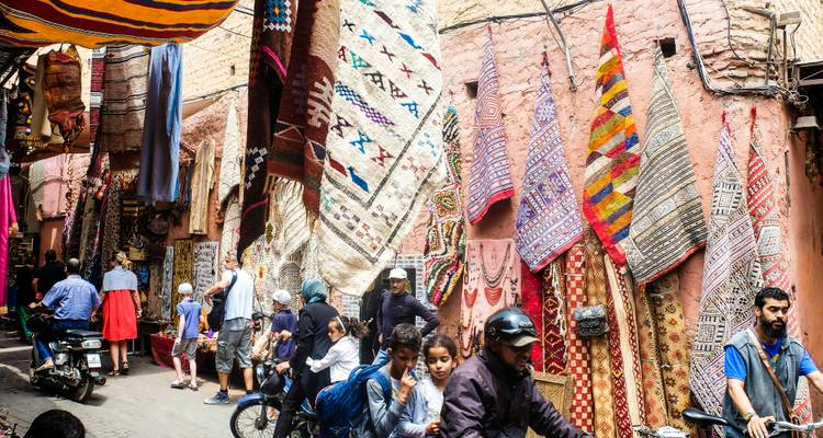 Street market with colorful fabrics and people.
