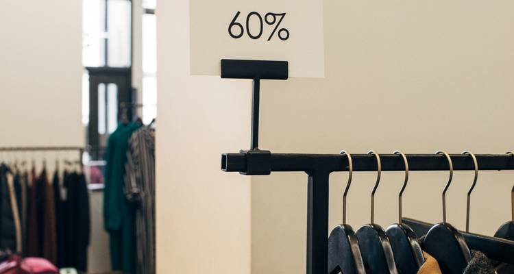 Clothing with a discount sign in a store.