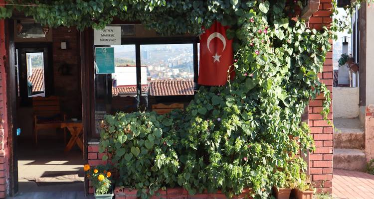 House facade with plants and a Turkish flag.
