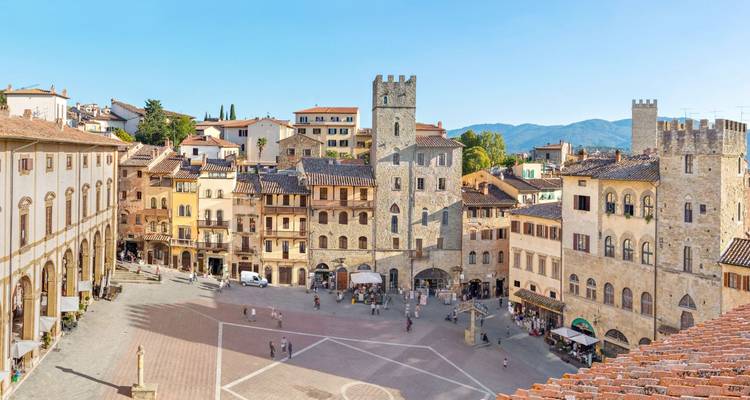 Historic square with medieval architecture and tourists.