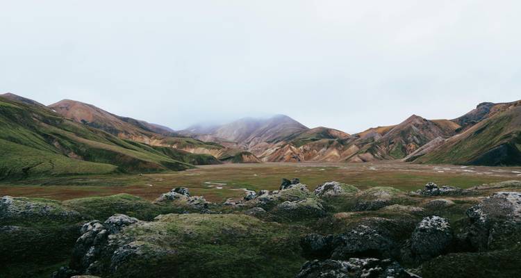 Wide landscape with colorful hills and clouds.