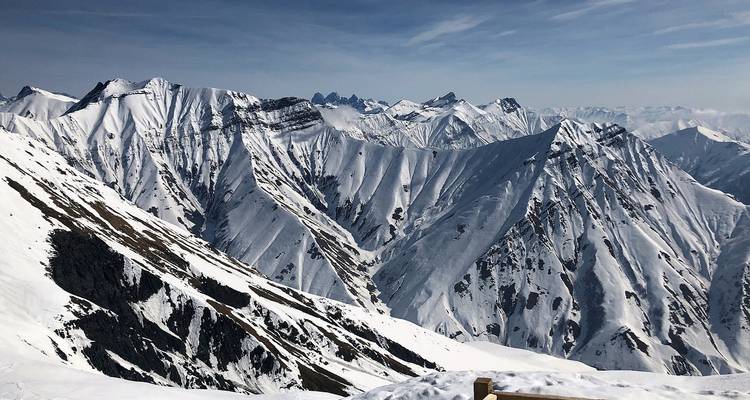 Chaîne de montagnes enneigée sous un ciel bleu clair.