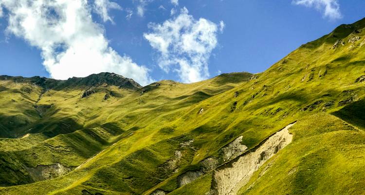 Des collines verdoyantes luxuriantes sous un ciel bleu clair.