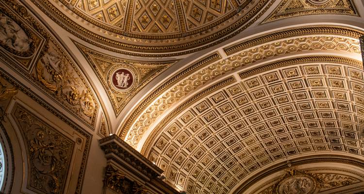 Intricately patterned ceiling with golden hues in a historic building