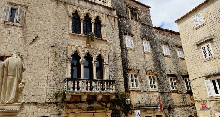 Historic stone buildings in a Croatian town square.