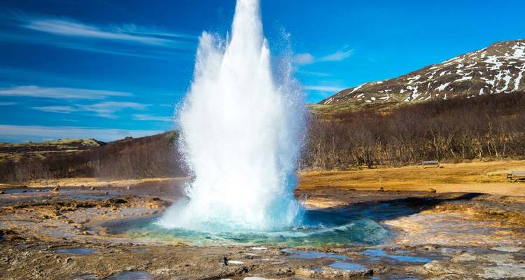 Un geyser en éruption dans un paysage naturel.