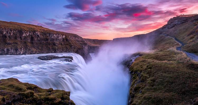 Un coucher de soleil vibrant au-dessus d'un paysage de cascade spectaculaire.