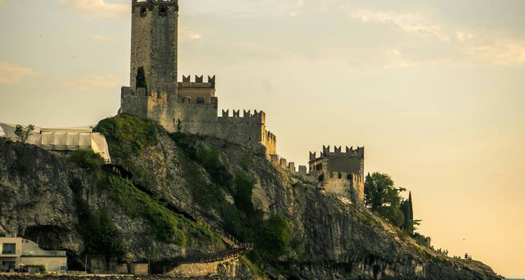 Castillo histórico en acantilado al atardecer.