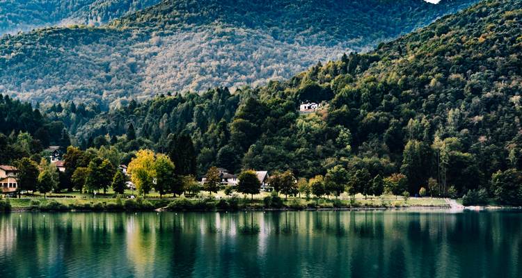 Paisaje exuberante con un lago y colinas boscosas.