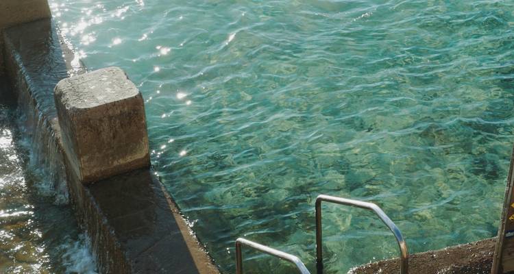 Primer plano de una piscina o cuerpo de agua con escalones que conducen hacia adentro.