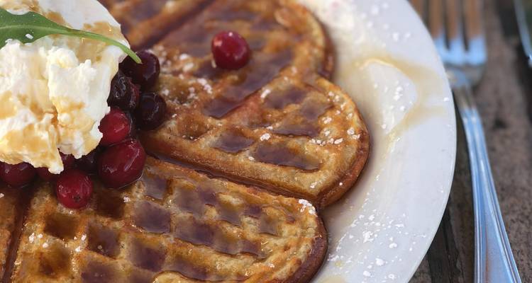 Plate with waffles topped with cream and berries.