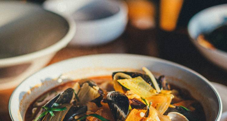 Bowl of seafood stew with visible shellfish.