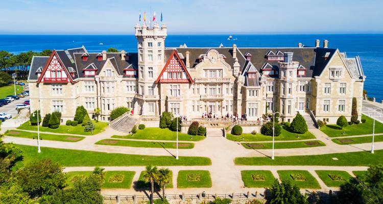 An elegant palace with well-maintained gardens by the sea.