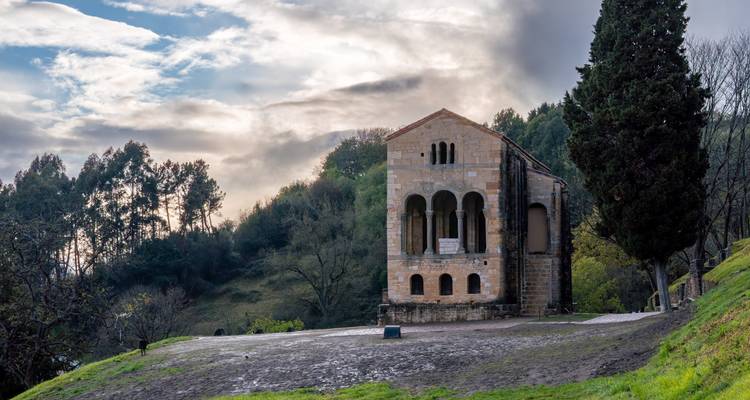 A historic church with a mountainous backdrop.