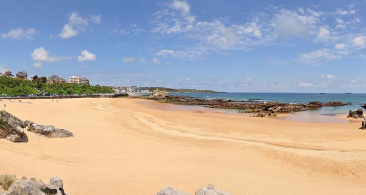 A sandy beach stretching along a coastal town.