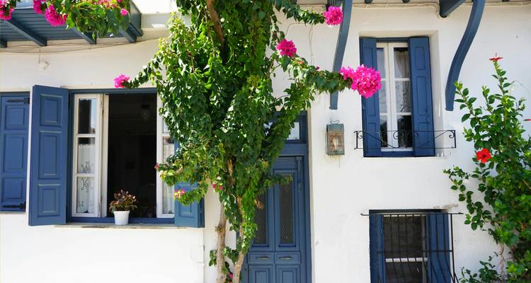 Traditional Greek house with vibrant pink flowers.