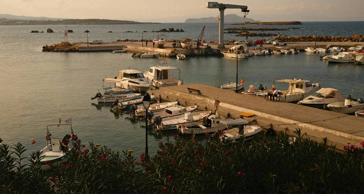 Small harbor with boats and a rocky breakwater.