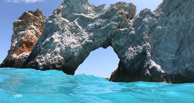Rocky arch formation in blue waters.