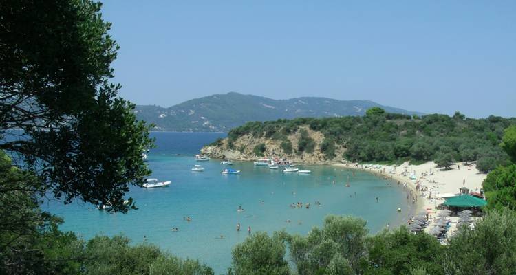 People enjoying a beach with clear blue water.