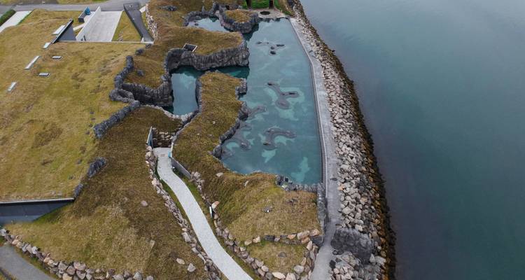 Aerial view of a rocky coastline and calm water.