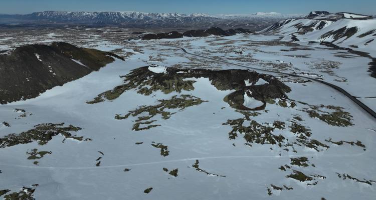 Snowy plateau with surrounding mountains and roads.