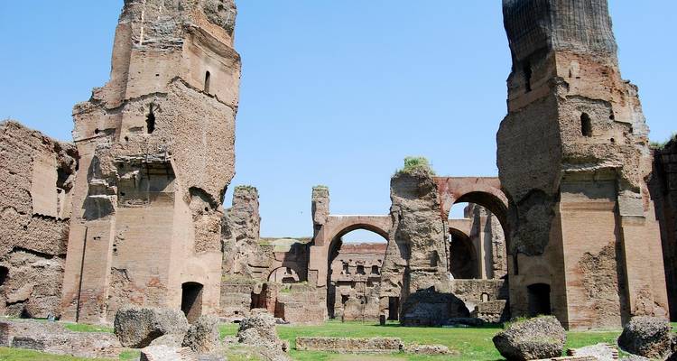 Ruines antiques en brique avec arches et zones herbeuses.