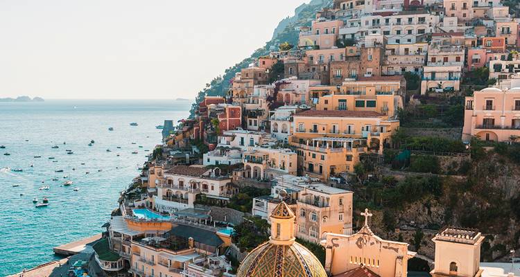La pintoresca Positano con edificios en tonos pastel que trepan por una empinada ladera sobre el mar Tirreno turquesa