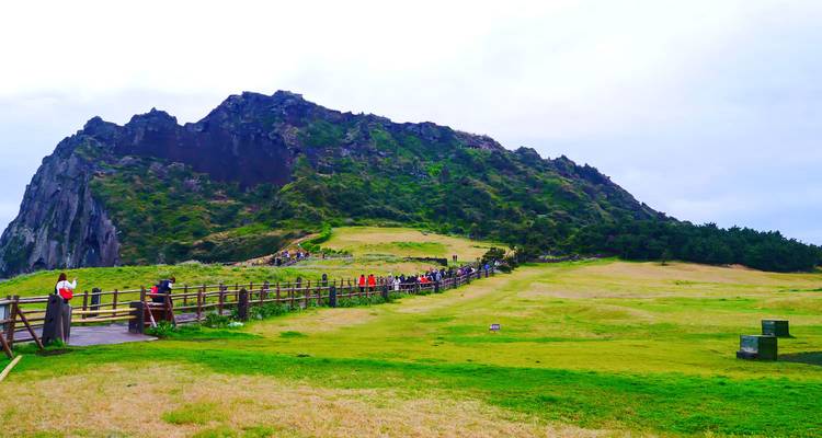 Seongsan Ilchulbong à Jeju avec des personnes marchant le long d'un sentier.