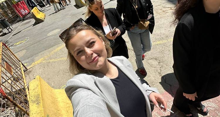 Des gens qui marchent et prennent des selfies dans une rue de la ville.