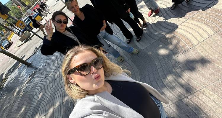 Selfie de groupe avec des personnes qui posent sur une rue pavée.