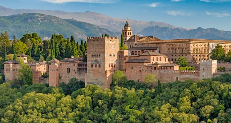 Malerischer Blick auf die Alhambra mit Bergen und üppigem Grün.