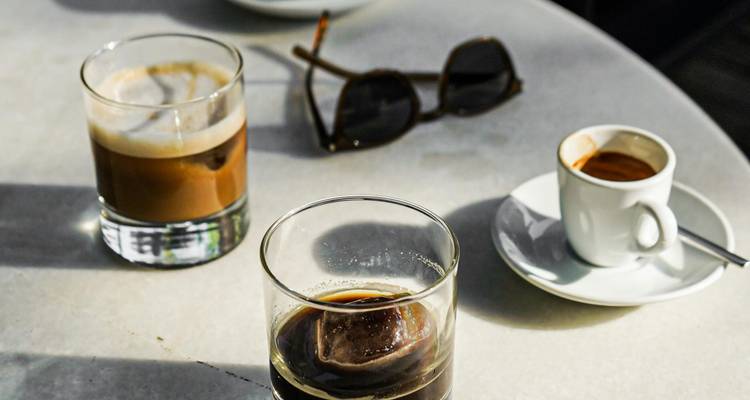 Table avec divers verres de café et des lunettes de soleil.